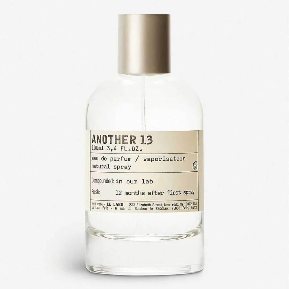 Clear glass perfume bottle with a beige label reading 'ANOTHER 13' and a metallic cap on a white background.