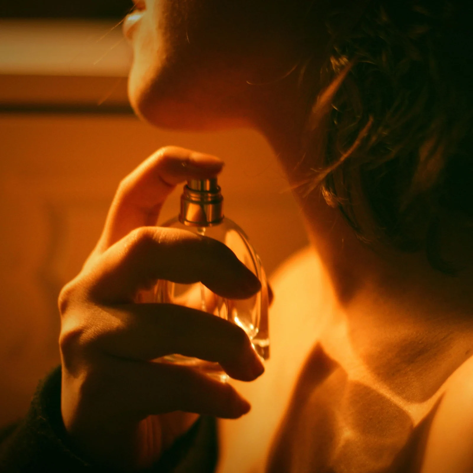 Close-up of a person bringing a lighter to their lips in warm amber light.