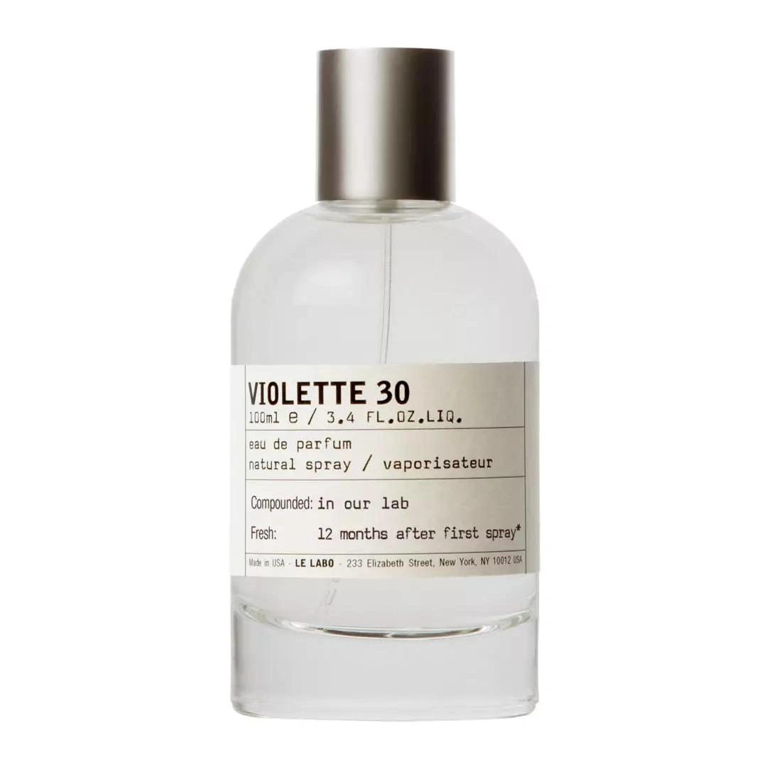 Perfume bottle with a silver cap and a beige label reading VIOLETTE 30 on clear glass.