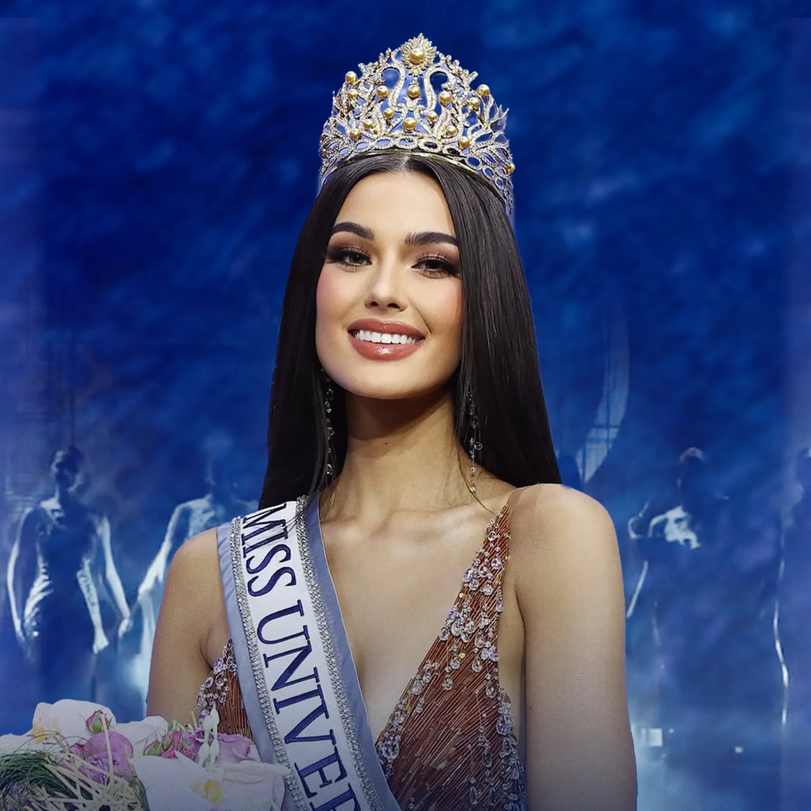 Miss pageant contestant wearing an ornate crown and sash, smiling, with a bouquet in the foreground.