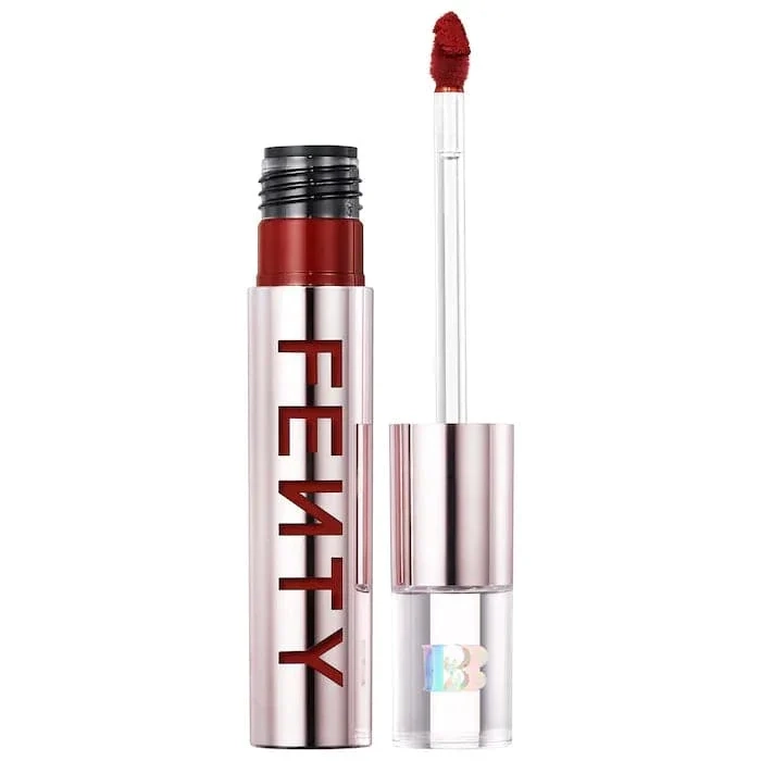 Lip gloss and applicator wand with a red shade in a pink metallic tube labeled FEATY (lip product).
